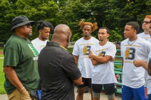 photo of coaches talking to men's basketball team