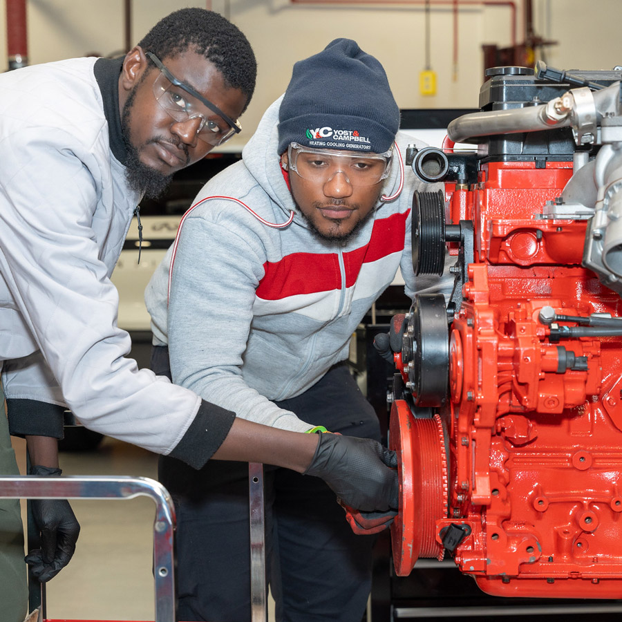 <i class="material-icons" ">article</i> Two BCC Students work on an Engine in the Automotive Tech Program