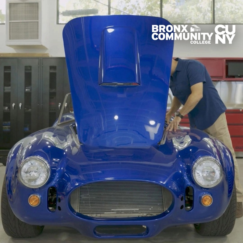 Image from the Automotive Technology curriculum, of a student working on a Cobra vehicle in the shop